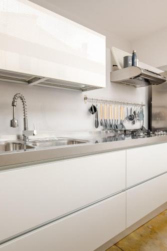 a kitchen with white cabinets and a sink at Tuscany Crossroad in Empoli