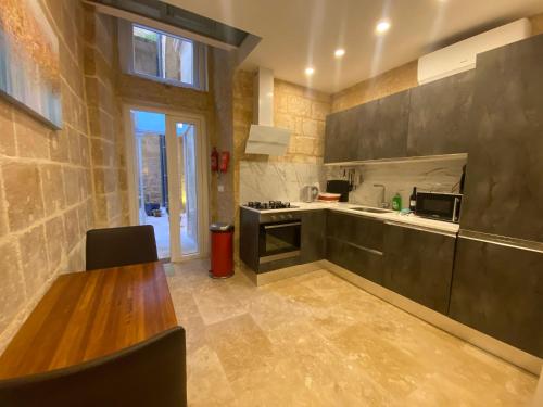 a kitchen with a wooden table and a counter top at Valletta St Ursula in Valletta