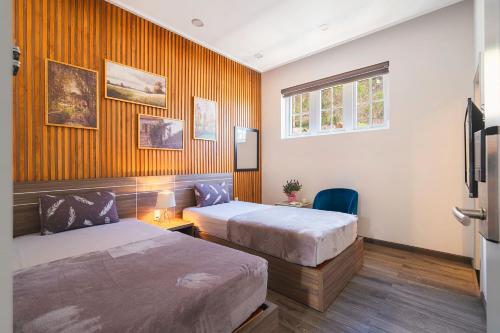 a hotel room with two beds and a window at La Cle' Đà Lạt in Da Lat