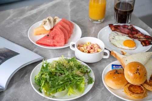 a table with plates of breakfast food on it at Z HOTEL- Qingchengshan in Dujiangyan