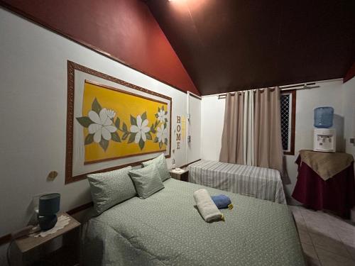 a bedroom with a bed and a painting on the wall at Chez Tamatuamai in Avatoru