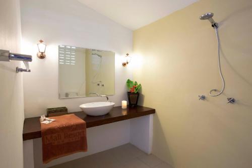 ein Badezimmer mit Waschbecken und Spiegel in der Unterkunft Mali Resort Pattaya Beach Koh Lipe in Ko Lipe