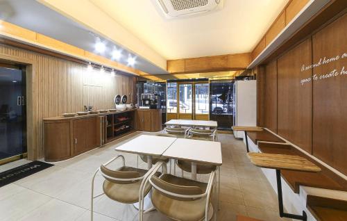 a kitchen with a table and chairs in a room at Hotel Yoegieottae Gwangju Station in Gwangju