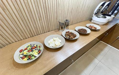 a counter with four plates of food on it at Hotel Yoegieottae Gwangju Station in Gwangju