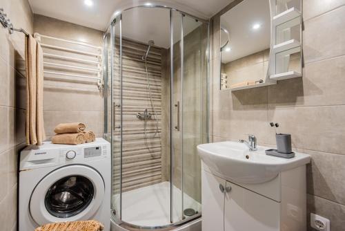 Un baño con lavadora y lavabo. en NIDA made, en Nida
