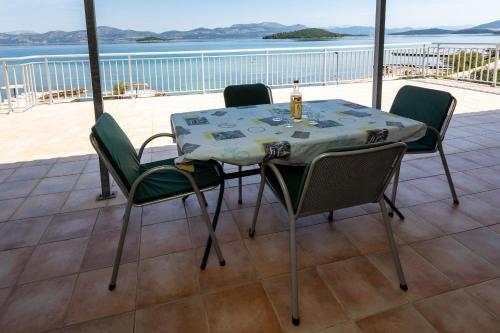 a table and chairs on a balcony with a view of the ocean at Mediterranean Seaside Apartments - Deak in Drače