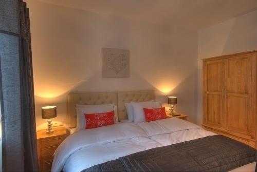 a bedroom with a large bed with red pillows at Chalet Apartment Ski and Golf by Kaprun Rentals in Zell am See