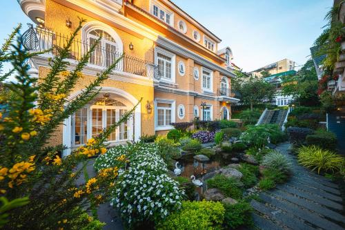 a large building with a garden in front of it at La Cle' Đà Lạt in Da Lat