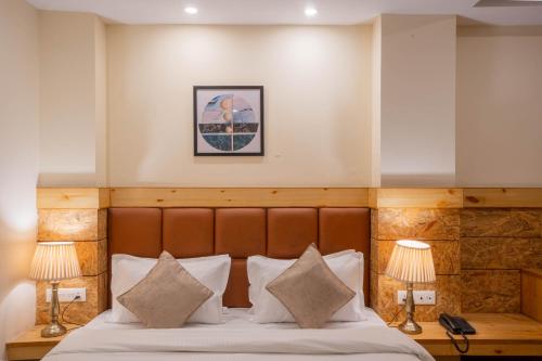 a hotel room with a bed with two lamps at Perfectstayz Value Valley Vista 5 min walk to Mall road in Mussoorie