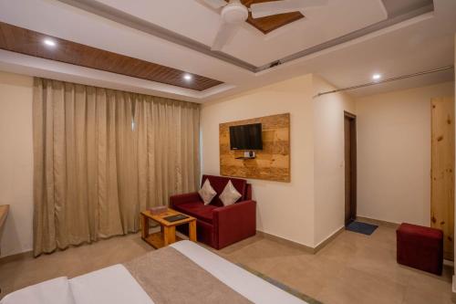 a bedroom with a bed and a chair and a tv at Perfectstayz Value Valley Vista 5 min walk to Mall road in Mussoorie