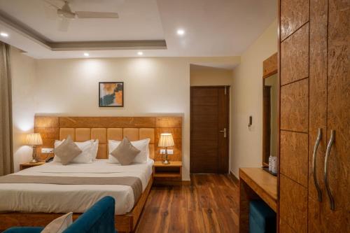 a bedroom with a large bed and wooden floors at Perfectstayz Value Valley Vista 5 min walk to Mall road in Mussoorie
