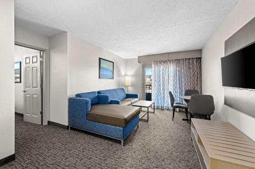 a hotel room with a blue couch and a table at Quality Inn & Suites at Dollywood Lane in Pigeon Forge