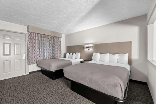 a hotel room with two beds and a window at Quality Inn & Suites at Dollywood Lane in Pigeon Forge