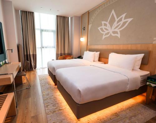 a hotel room with two beds and a flat screen tv at Hilton Garden Inn Samarkand Sogd in Samarkand