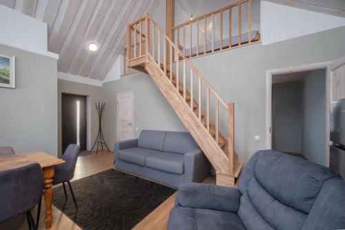 a living room with a staircase and a blue couch at Kaljuranna puhkemaja in Kodavere