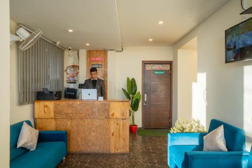 a man standing at a counter with a laptop at Perfectstayz Value Valley Vista 5 min walk to Mall road in Mussoorie