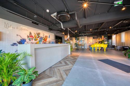a lobby with a reception desk and plants at Vienna House Easy by Wyndham Amsterdam Airport Schiphol in Hoofddorp