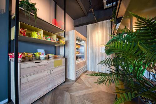 a kitchen with wooden cabinets and a plant at Vienna House Easy by Wyndham Amsterdam Airport Schiphol in Hoofddorp
