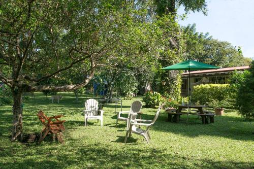 a yard with chairs and a table and an umbrella at Airport Costa Rica B&B in Alajuela City