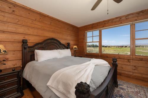 a bedroom with a bed in a room with wooden walls at 19th Hole cabin in Granby