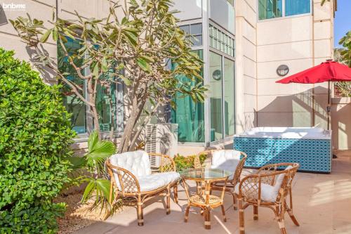 a patio with chairs and a glass table and umbrella at bnbmehomes - Anbar Tower in Dubai