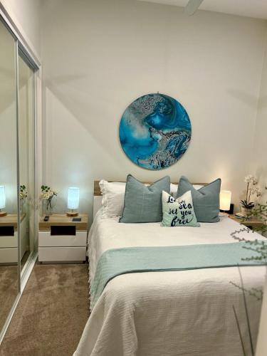 a bedroom with a bed with a blue painting on the wall at Woonona Family Beach Villa 5 min walk to beach in Woonona