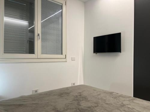 a bedroom with a tv on the wall and a window at residenza CLASMARINA5 nuova costruzione posizione strategica in Marina di Campo