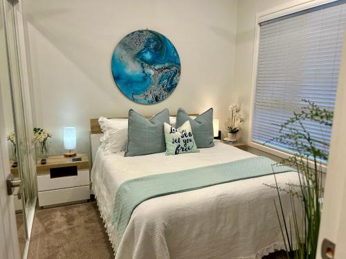 1 dormitorio con 1 cama con un plato azul en la pared en Woonona Family Beach Villa 2 bedroom Brand new, en Woonona