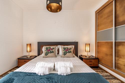 a bedroom with a large bed with two night stands at Serra e Mar Refuge in Sesimbra - Family Friendly home near the Arrábida Beachs in Sesimbra