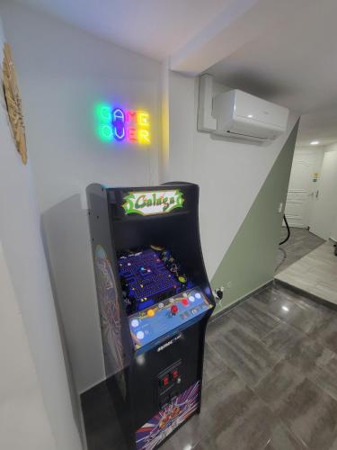 a video game machine in a room with a neon sign at Casa Bella - Borne arcade, Baby-Foot, Extérieur in Thiers