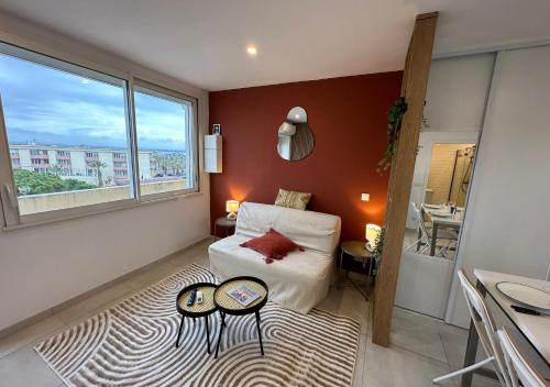 a bedroom with a bed and two tables on a rug at Le Studio Terracotta - Central & Lumineux in Palavas-les-Flots