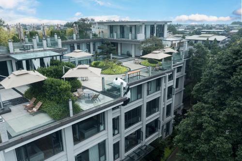 an apartment building with tables and umbrellas on the roof at Z HOTEL- Qingchengshan in Dujiangyan