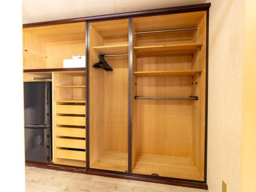 a walk in closet with wooden shelves and a refrigerator at まち宿門 in Nakatsugawa