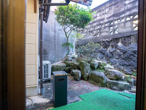 a garden with a trash can next to a building at まち宿門 in Nakatsugawa