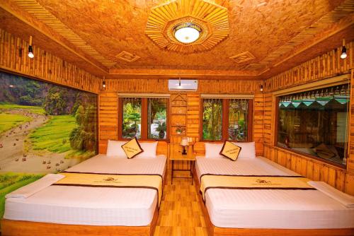 three beds in a room with windows at Xuan Son Lakeside Bungalow in Ninh Binh