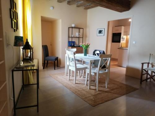 une salle à manger avec une table et des chaises blanches dans l'établissement La La Loc, à Cosne Cours sur Loire