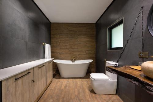 a bathroom with a tub and a toilet and a sink at Pax Manor Muthaiga in Nairobi