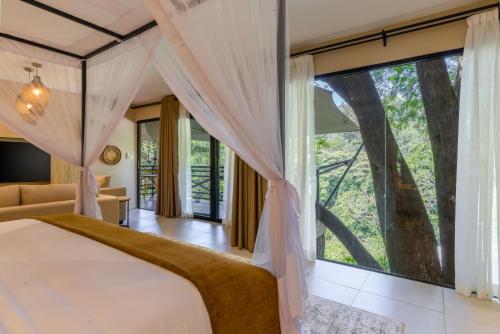 a bedroom with a bed and a large window at Pax Manor Muthaiga in Nairobi