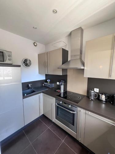 une cuisine avec des armoires blanches et des appareils en acier inoxydable dans l'établissement Studio Apartment - Close to Croisette & Martinez, à Cannes