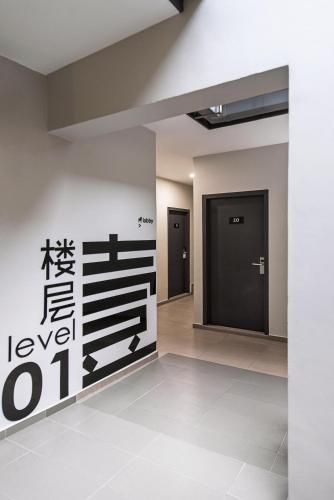 an empty lobby with a black door and a wall at Hako Hotel Taman U in Johor Bahru