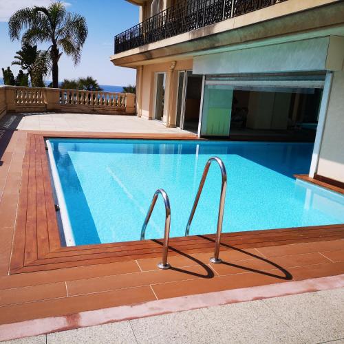 une piscine devant une maison dans l'établissement Le Victoria Beach, à Menton