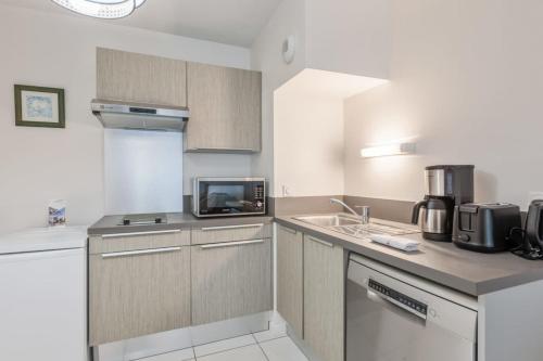 une cuisine avec un évier et un micro-ondes dans l'établissement Beautiful apartment - near the beach, à La Rochelle