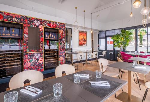 a restaurant with tables and chairs and a bar at Domaine du Limonay, The Originals Collection in Saint-Méloir-des-Ondes