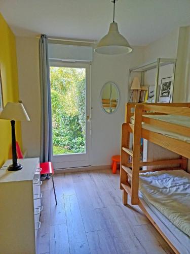 une chambre avec un lit superposé et une fenêtre dans l'établissement Bel appartement spacieux avec jardin et piscine, à Deauville