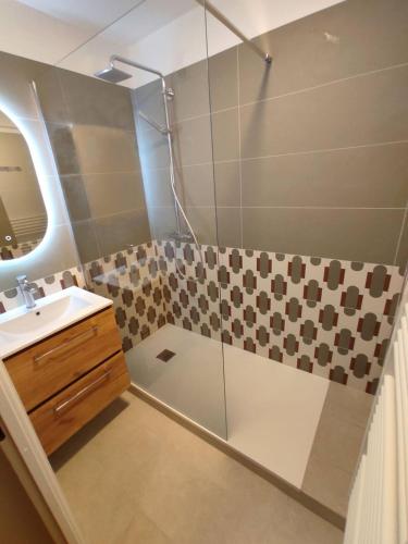 une salle de bain avec douche et lavabo dans l'établissement Bel appartement spacieux avec jardin et piscine, à Deauville