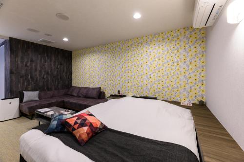 a bedroom with a bed and a couch at HOTEL FARINA DOLCE (Adult Only) in Kanuma