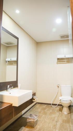 a bathroom with a sink and a toilet and a mirror at Tasneem Hotel Malioboro Yogyakarta in Yogyakarta