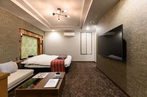 a hotel room with a bed and a flat screen tv at HOTEL FARINA DOLCE (Adult Only) in Kanuma