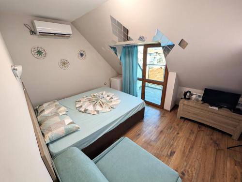 a small bedroom with a bed and a chair at Guest house Sineva in Primorsko