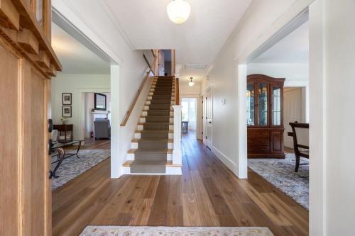 eine Treppe in einem Haus mit weißen Wänden und Holzböden in der Unterkunft American Foursquare Craftsman Spacious and Light 4285 in Hood River
